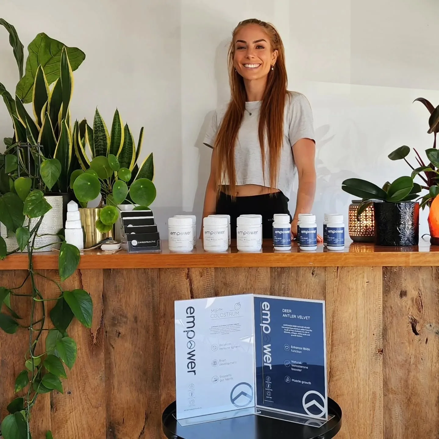 Pro Chiropractic clinic interior — warm timber reception counter with potted plants